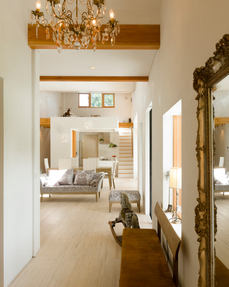 Foto de recibidores y pasillos bohemios con paredes blancas, suelo de madera clara, suelo beige y iluminación