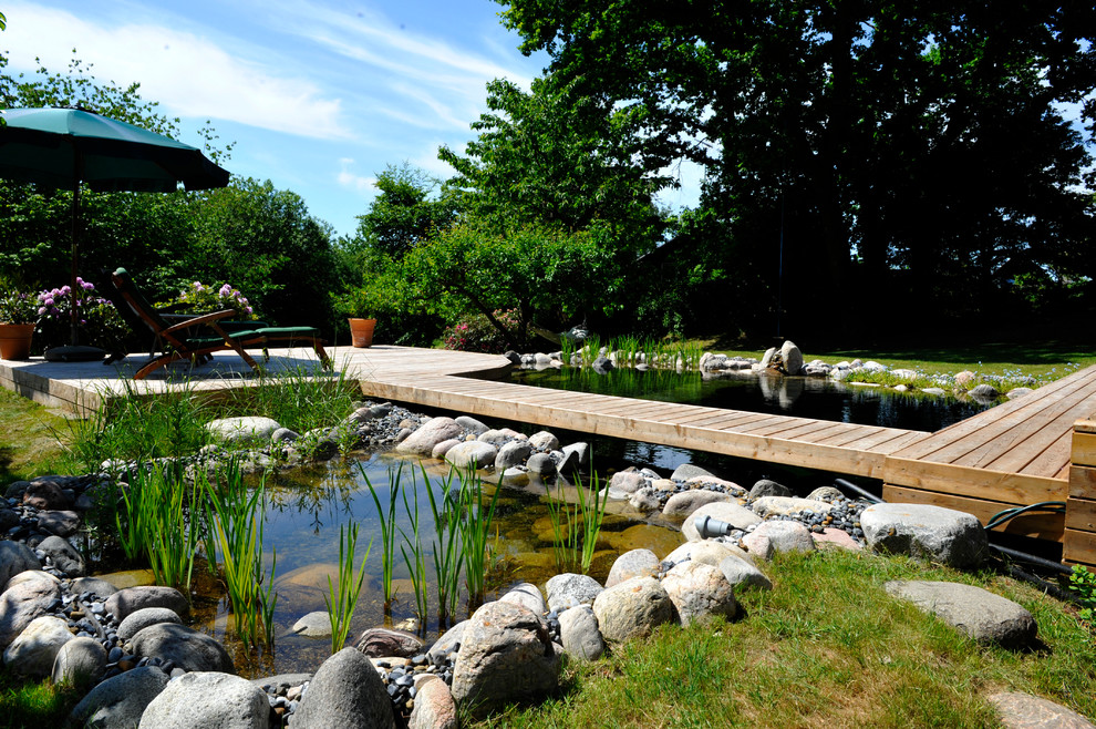 他の地域にある高級な中くらいな、夏のおしゃれな庭 (池、日向、天然石敷き) の写真