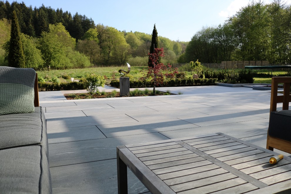 Idée de décoration pour un grand jardin minimaliste avec une exposition partiellement ombragée et des pavés en pierre naturelle.