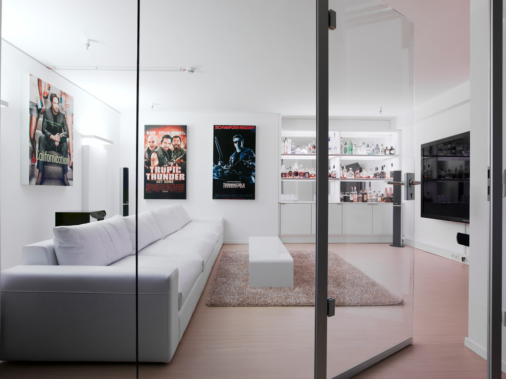 Mittelgroßes, Abgetrenntes Modernes Heimkino mit weißer Wandfarbe, hellem Holzboden und TV-Wand in Stuttgart