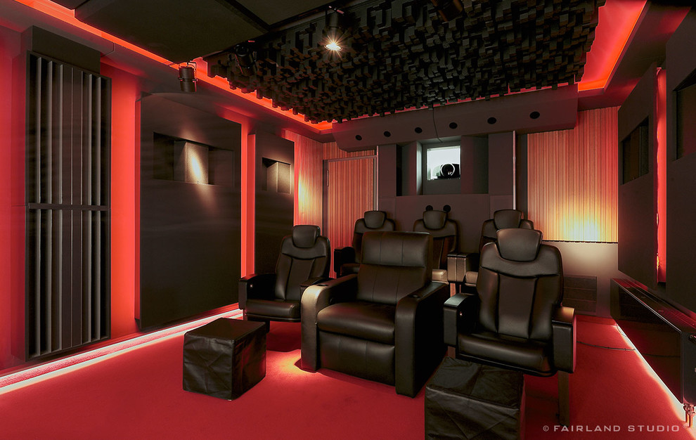 Идея дизайна: изолированный домашний кинотеатр среднего размера в стиле лофт с ковровым покрытием, проектором и красным полом