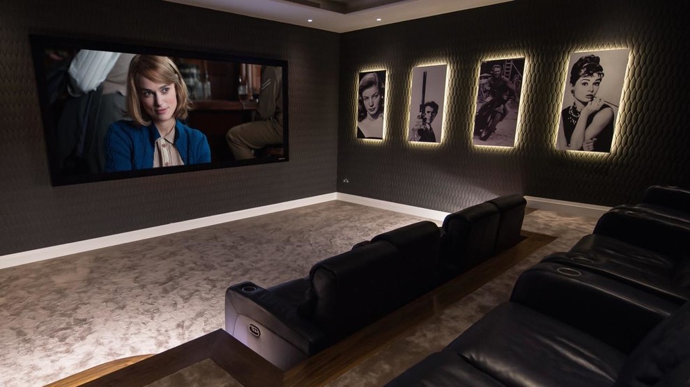 Diseño de cine en casa cerrado contemporáneo grande con paredes negras, moqueta y pantalla de proyección