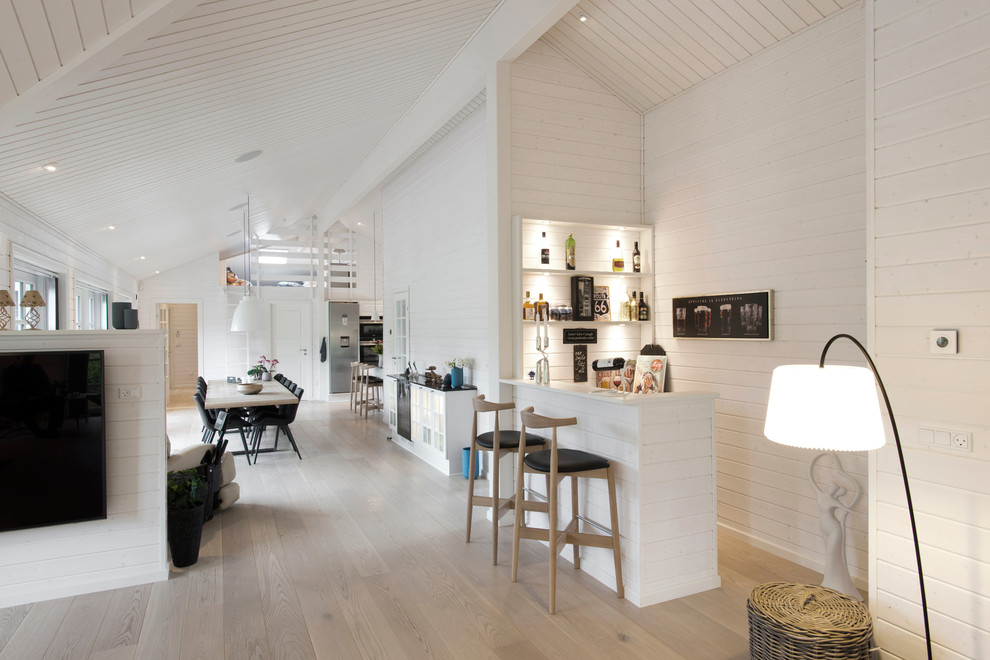 Aménagement d'un bar de salon linéaire scandinave de taille moyenne avec des tabourets, un placard sans porte, parquet clair et un sol beige.