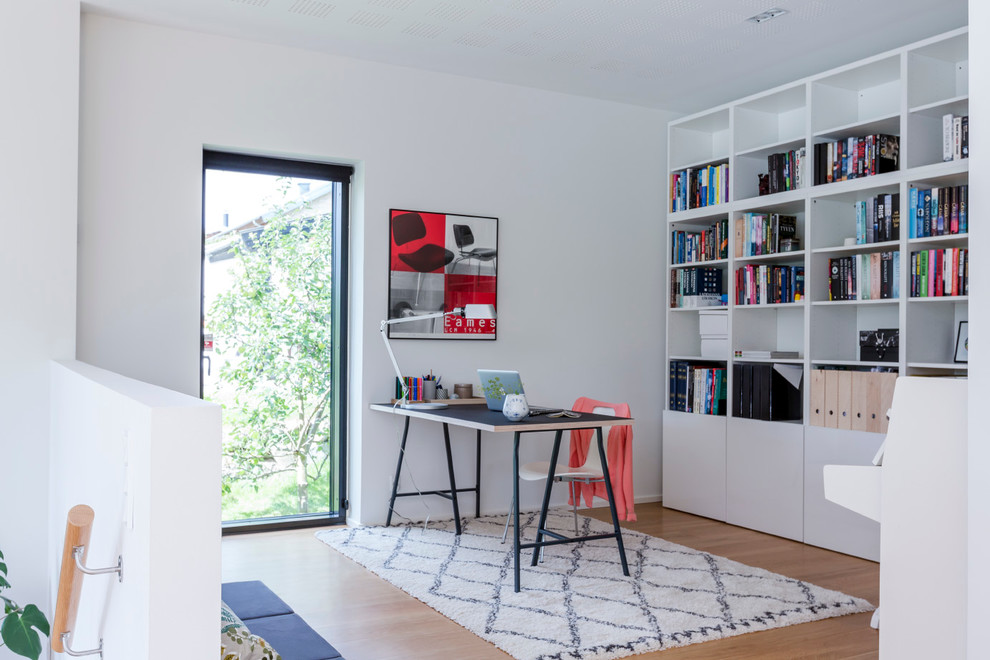 Modelo de despacho nórdico con paredes beige, suelo de madera clara y escritorio independiente