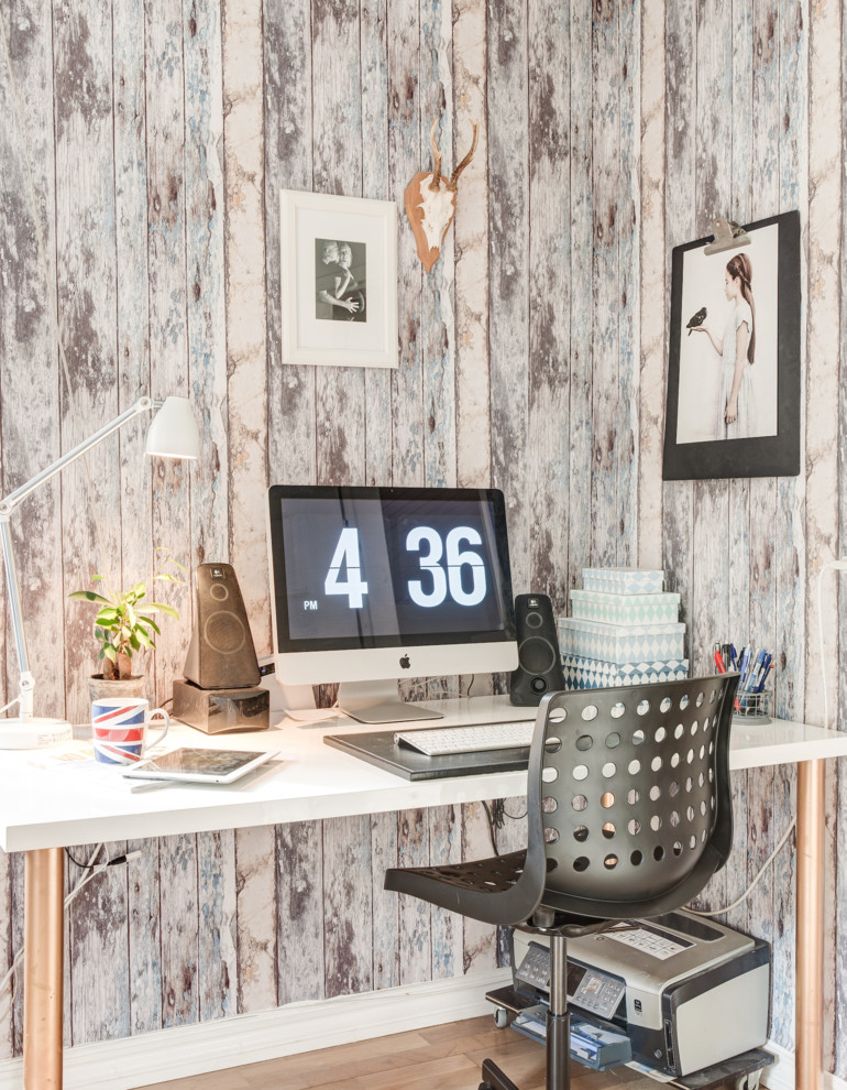 Imagen de despacho industrial pequeño con suelo de madera en tonos medios, escritorio independiente y paredes multicolor