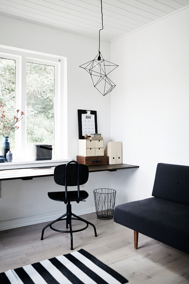 Inspiration for a medium sized scandinavian home office in Aarhus with white walls, light hardwood flooring, a built-in desk and grey floors.