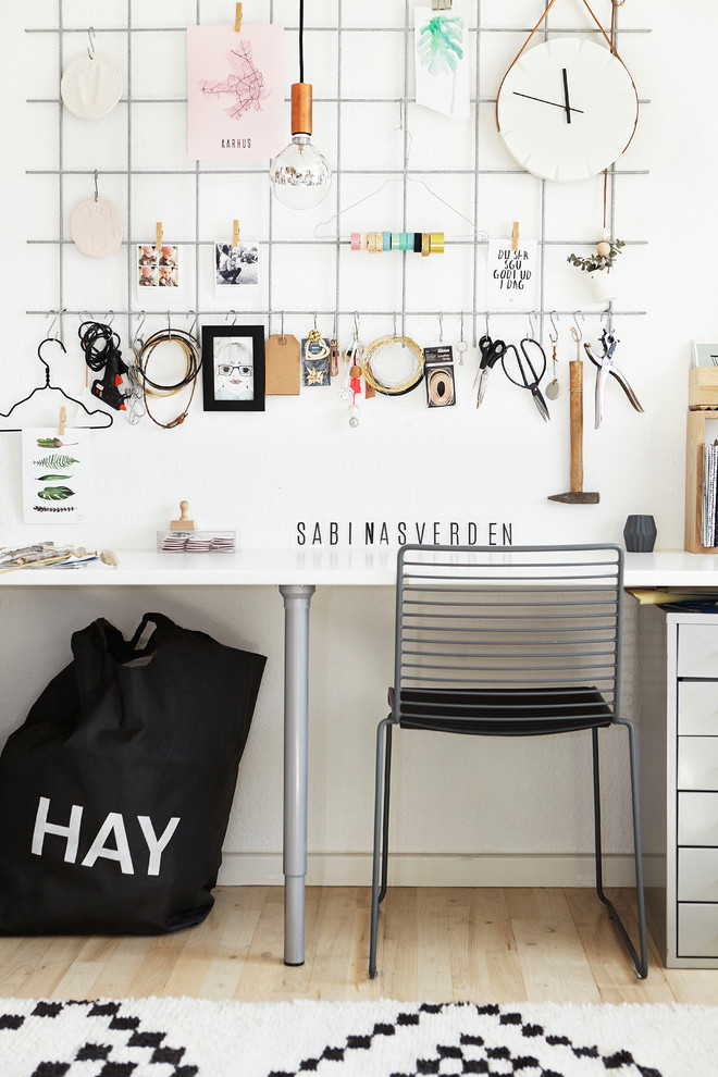 Idéer för minimalistiska hobbyrum, med vita väggar, ljust trägolv och ett inbyggt skrivbord