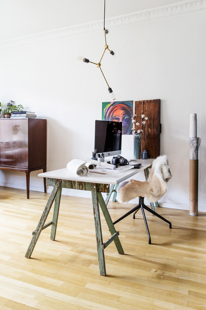 Immagine di uno studio nordico con pareti bianche, parquet chiaro e scrivania autoportante