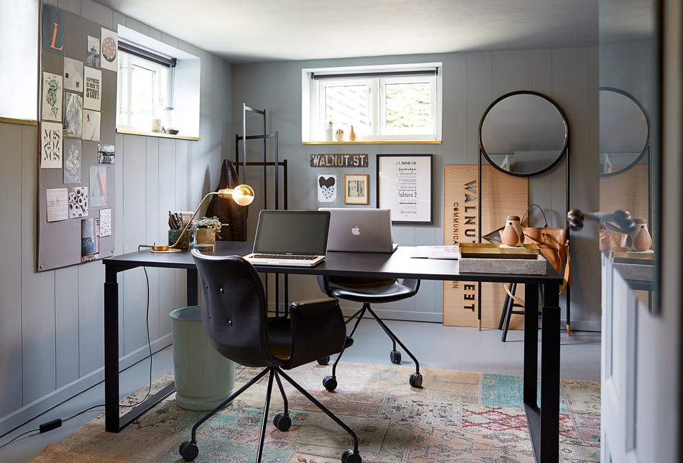 Cette photo montre un bureau tendance avec un mur gris, un bureau indépendant et un sol gris.