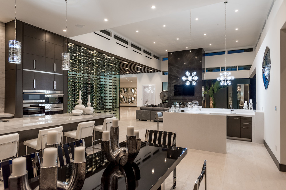 Large contemporary u-shaped breakfast bar in Las Vegas with a submerged sink, flat-panel cabinets, dark wood cabinets, engineered stone countertops, ceramic flooring, beige floors and white worktops.