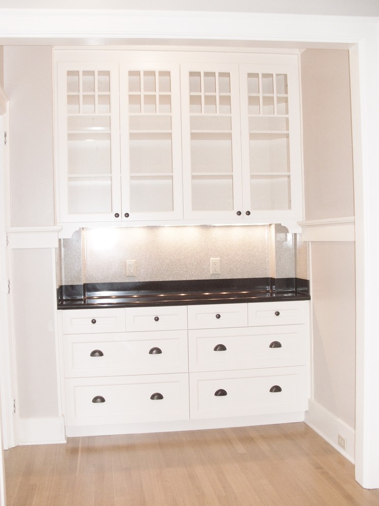 Exempel på en liten klassisk linjär hemmabar med vask, med luckor med glaspanel, vita skåp, grått stänkskydd, stänkskydd i keramik, ljust trägolv och beiget golv