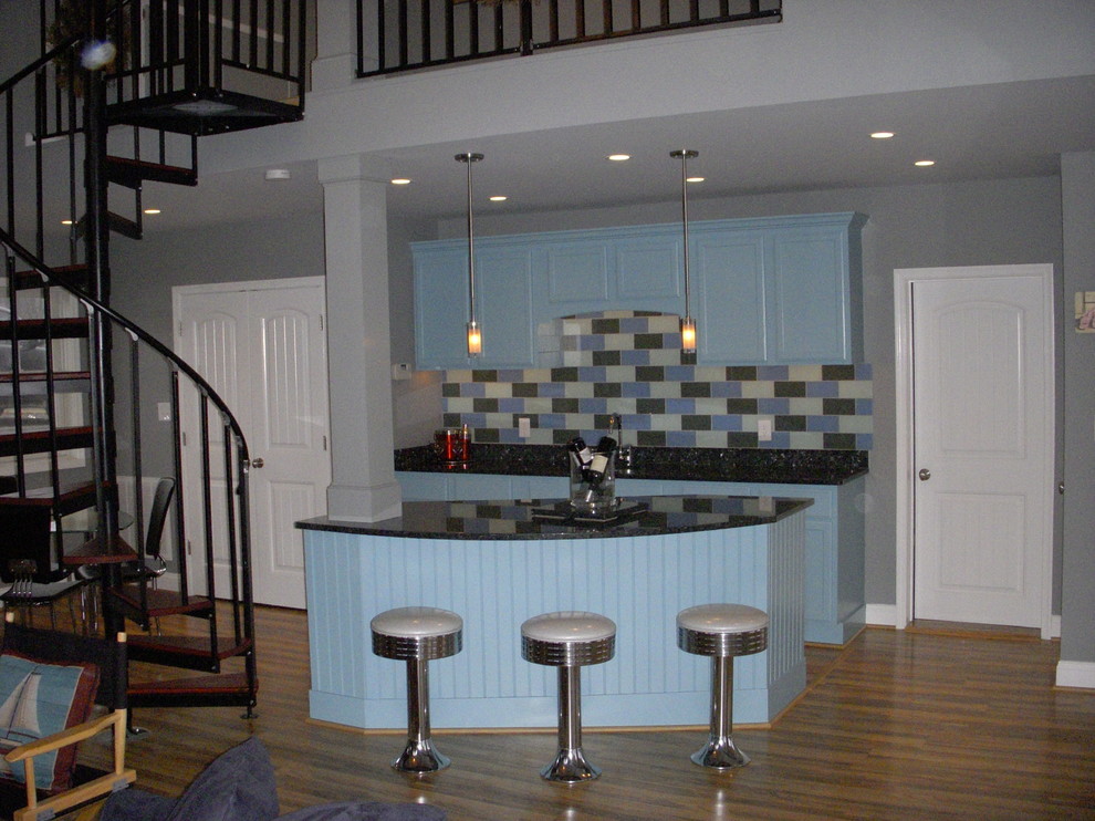 Foto di un piccolo angolo bar con lavandino country con lavello sottopiano, ante blu, top in granito, paraspruzzi grigio, paraspruzzi con piastrelle di vetro e parquet chiaro
