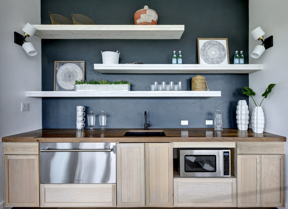 Design ideas for a contemporary single-wall home bar in Austin with a submerged sink, shaker cabinets, light wood cabinets, wood worktops, black splashback and brown worktops.