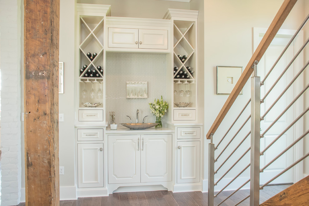 This is an example of a small country single-wall wet bar in New Orleans with white cabinets.