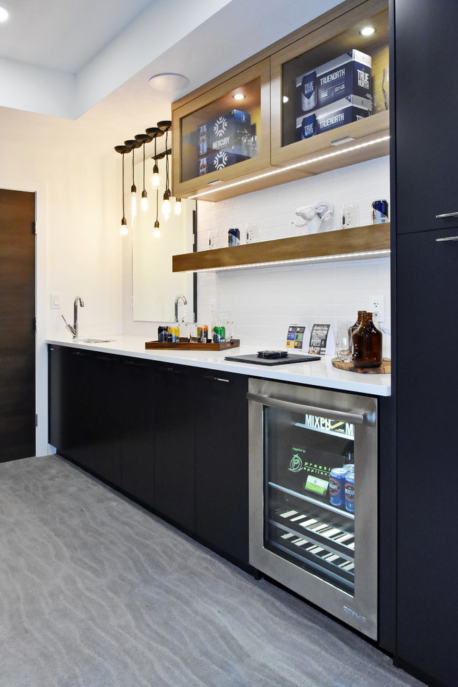 Example of a mid-sized trendy single-wall wet bar design in Edmonton with an undermount sink, flat-panel cabinets, black cabinets, quartz countertops and white countertops
