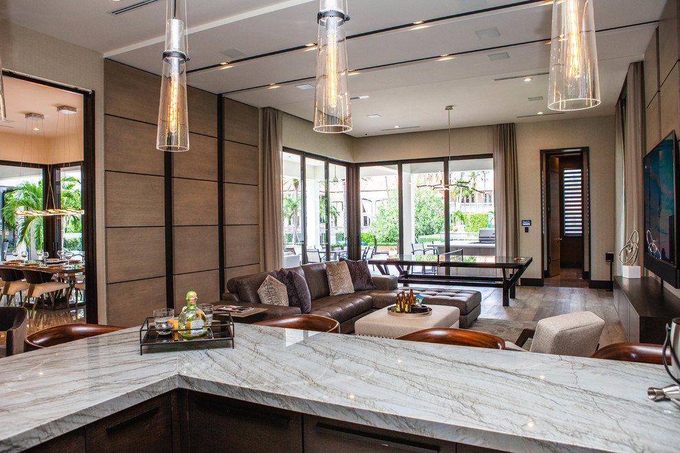 Inspiration for a mid-sized contemporary l-shaped medium tone wood floor and brown floor seated home bar remodel in Miami with flat-panel cabinets, dark wood cabinets, granite countertops, glass sheet backsplash and multicolored countertops