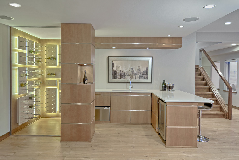 Moderne Hausbar in L-Form mit hellem Holzboden, Bartheke, flächenbündigen Schrankfronten, hellen Holzschränken und weißer Arbeitsplatte in Sonstige