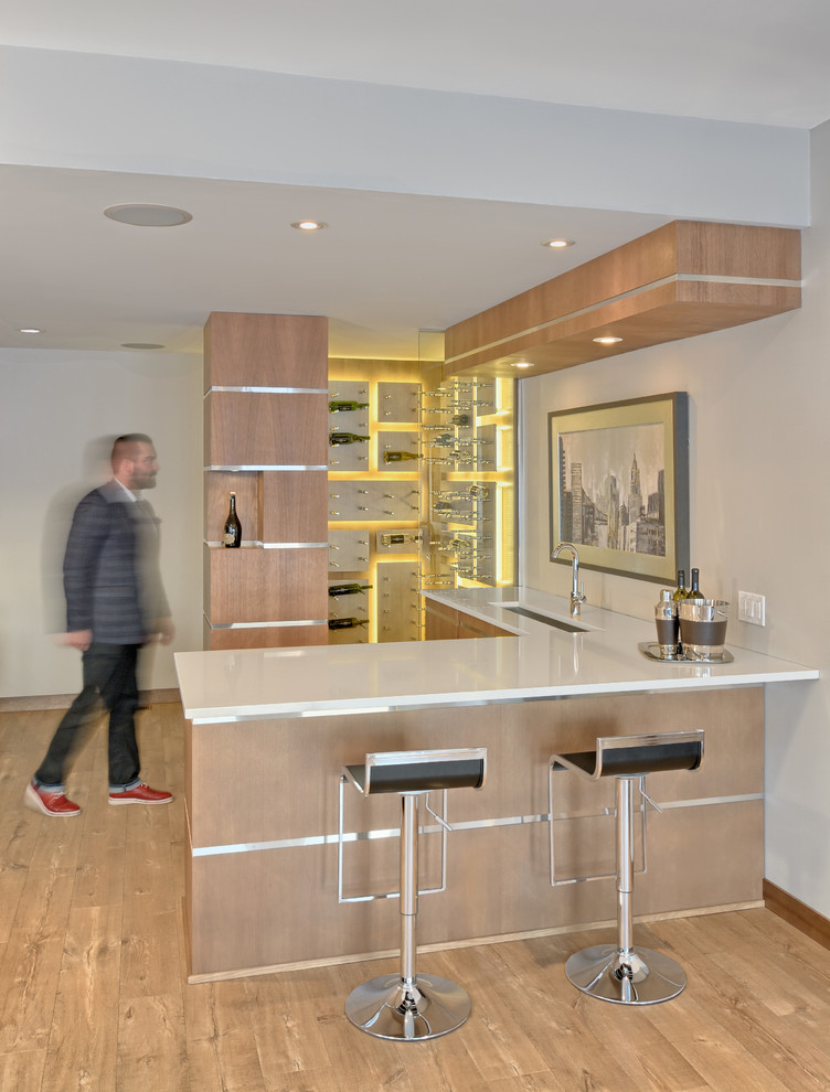 Idee per un bancone bar design con pavimento in legno massello medio, lavello sottopiano, ante lisce, ante in legno chiaro e pavimento beige