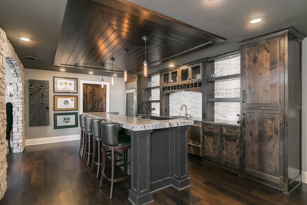 Inspiration for a large modern single-wall breakfast bar in Minneapolis with a submerged sink, shaker cabinets, distressed cabinets, granite worktops, white splashback, matchstick tiled splashback, dark hardwood flooring, brown floors and white worktops.