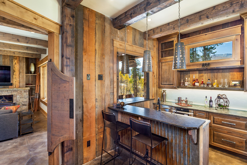 Aménagement d'un bar de salon parallèle montagne en bois brun avec des tabourets et un placard avec porte à panneau surélevé.