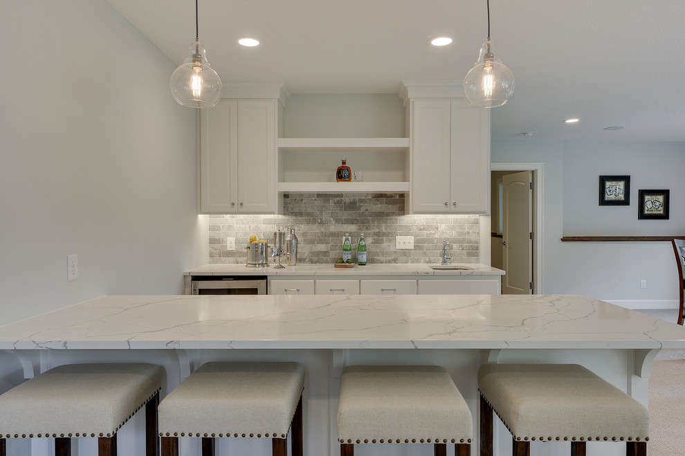 Design ideas for a large traditional breakfast bar in Minneapolis with a submerged sink, recessed-panel cabinets, white cabinets, engineered stone countertops, grey splashback, porcelain splashback, ceramic flooring and grey floors.