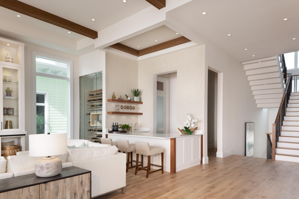 Photo of a medium sized classic u-shaped breakfast bar in Miami with a submerged sink, open cabinets, white cabinets, engineered stone countertops, light hardwood flooring, brown floors and white worktops.