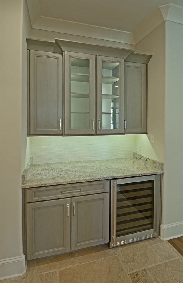 Inspiration for a small transitional single-wall limestone floor and beige floor wet bar remodel in Other with no sink, recessed-panel cabinets, gray cabinets, granite countertops, white backsplash and subway tile backsplash