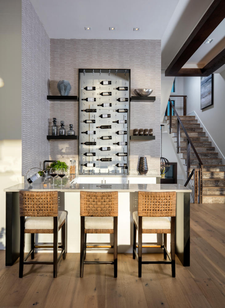 Diseño de bar en casa con barra de bar lineal exótico de tamaño medio con salpicadero beige, salpicadero de azulejos de piedra, suelo de madera en tonos medios y suelo marrón