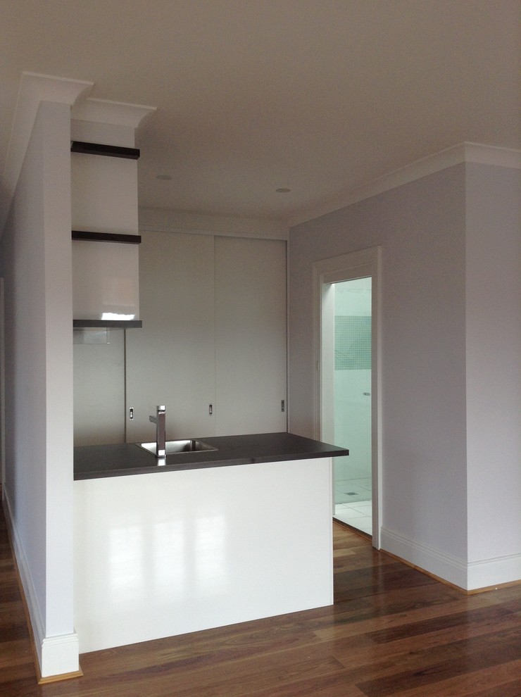 Kleine Moderne Hausbar in L-Form mit Unterbauwaschbecken und braunem Holzboden in Sydney