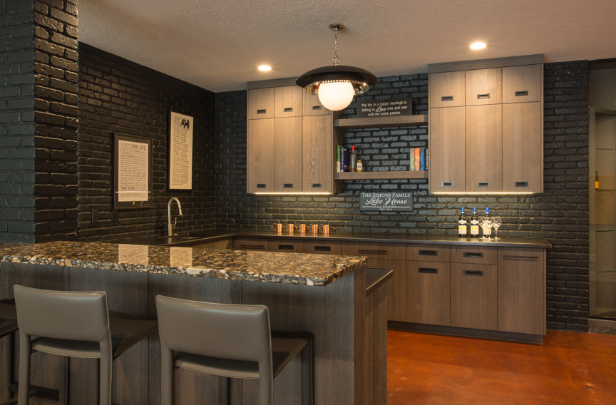 Inspiration for a large modern u-shaped carpeted and beige floor seated home bar remodel in Chicago with an undermount sink, flat-panel cabinets, light wood cabinets, granite countertops, black backsplash and brick backsplash