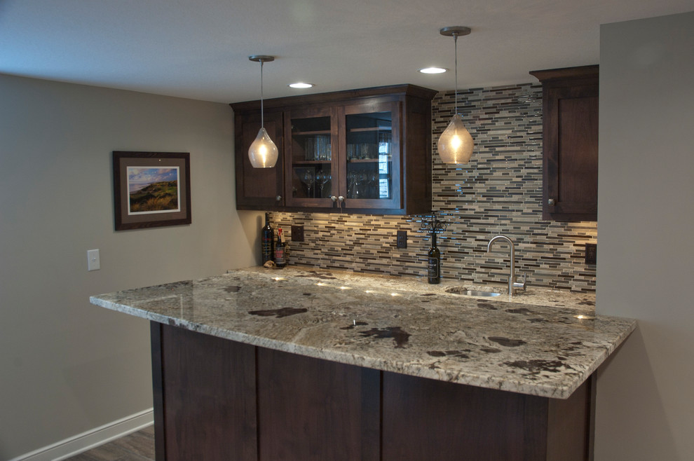 Photo of a large contemporary galley wet bar in Minneapolis with a submerged sink, flat-panel cabinets, dark wood cabinets, granite worktops, brown splashback and glass tiled splashback.