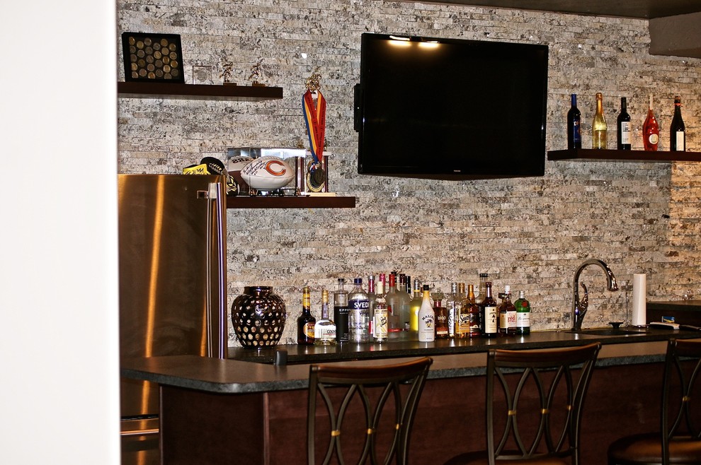 Esempio di un angolo bar tradizionale con paraspruzzi con piastrelle in pietra