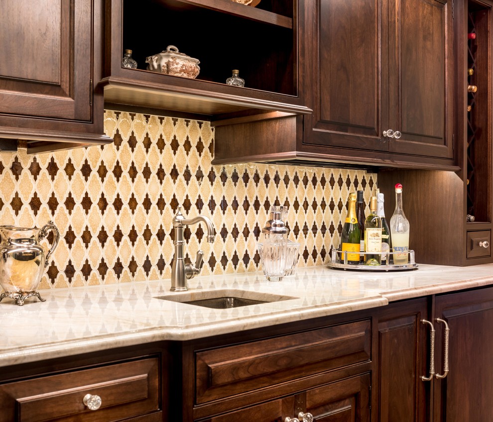 Elegant single-wall home bar photo in Philadelphia with raised-panel cabinets, dark wood cabinets, granite countertops, brown backsplash and ceramic backsplash
