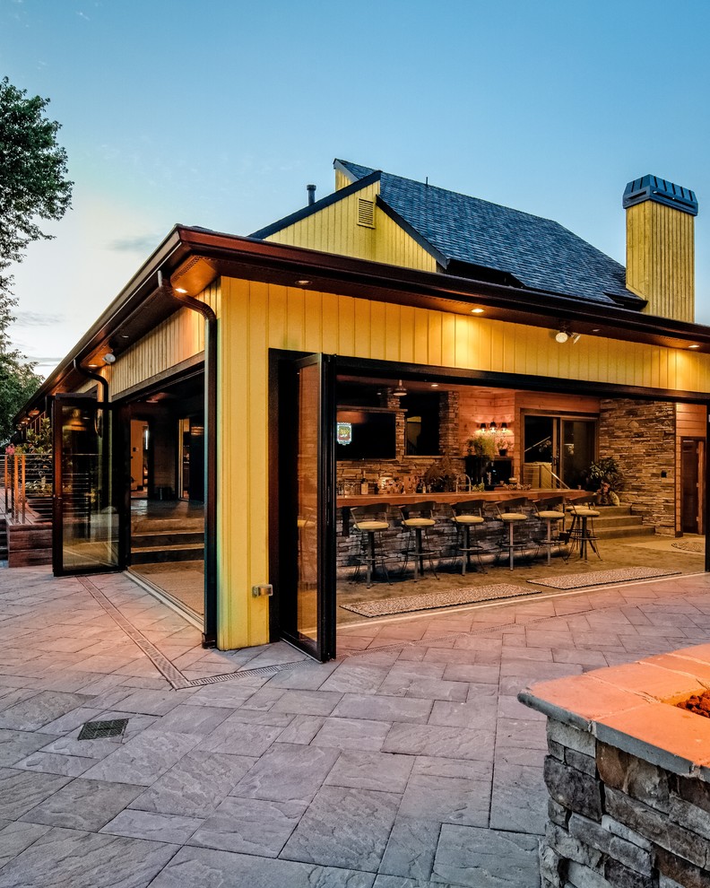 На фото: огромный прямой домашний бар в стиле рустика с барной стойкой, деревянной столешницей, разноцветным фартуком, фартуком из каменной плитки и бетонным полом