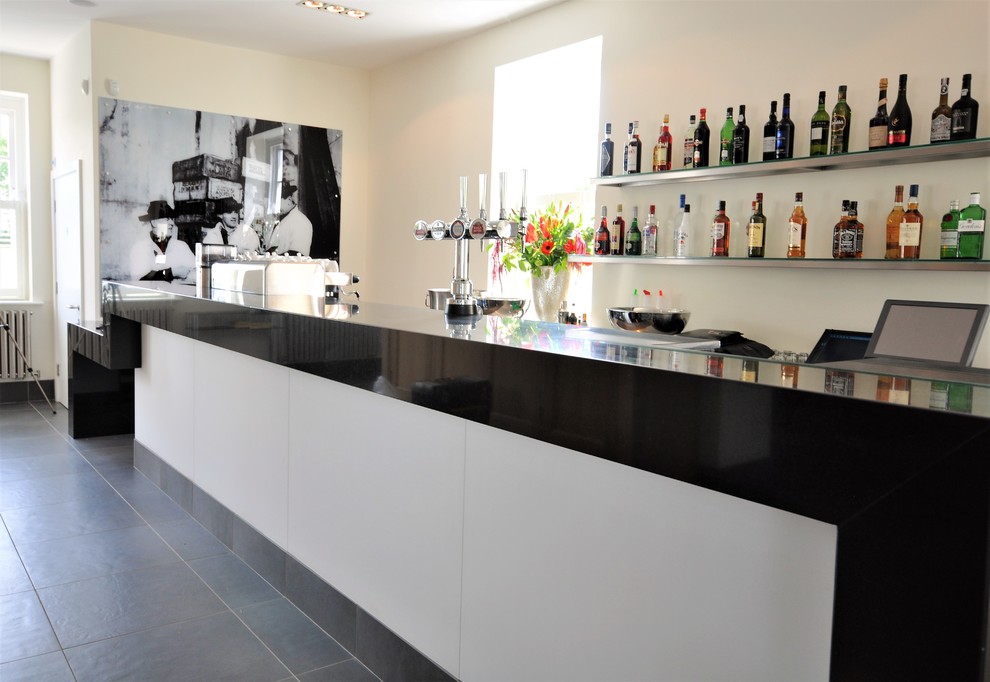 Imagen de bar en casa contemporáneo grande con encimera de granito, suelo de baldosas de porcelana, suelo gris y encimeras negras