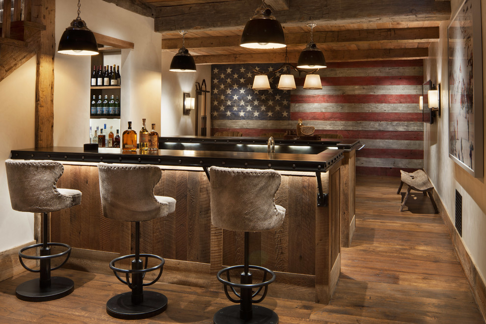 Ejemplo de bar en casa con barra de bar rural con encimeras negras, suelo de madera en tonos medios y suelo marrón