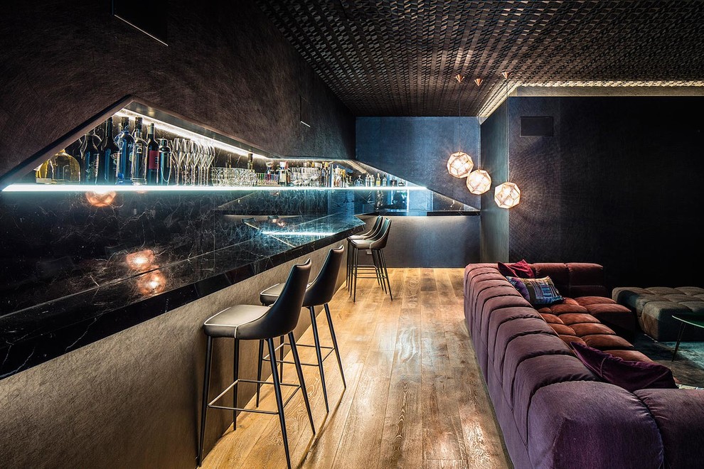 Idee per un grande angolo bar con lavandino minimalista con top in granito, paraspruzzi nero, paraspruzzi in lastra di pietra e parquet chiaro