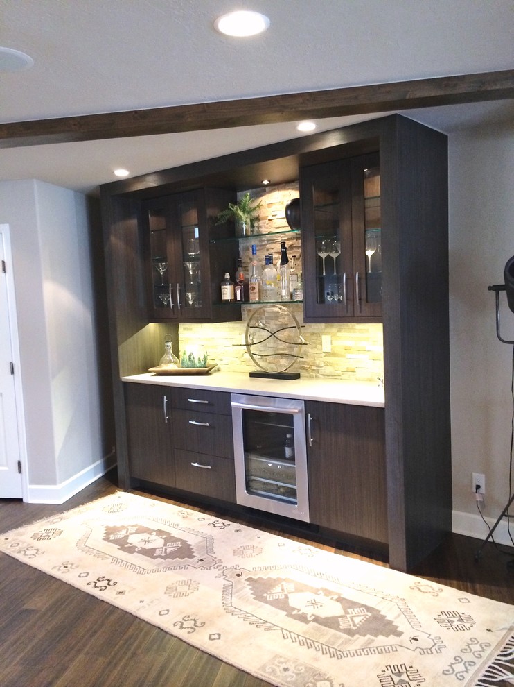 Small transitional single-wall dark wood floor and brown floor wet bar photo in Denver with flat-panel cabinets, dark wood cabinets, quartzite countertops, white backsplash and stone tile backsplash