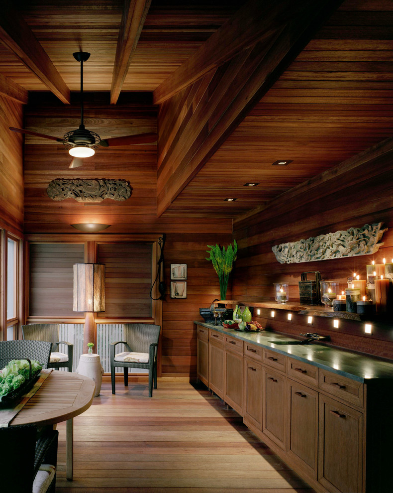 This is an example of a world-inspired single-wall home bar in New York with dark wood cabinets and wood splashback.