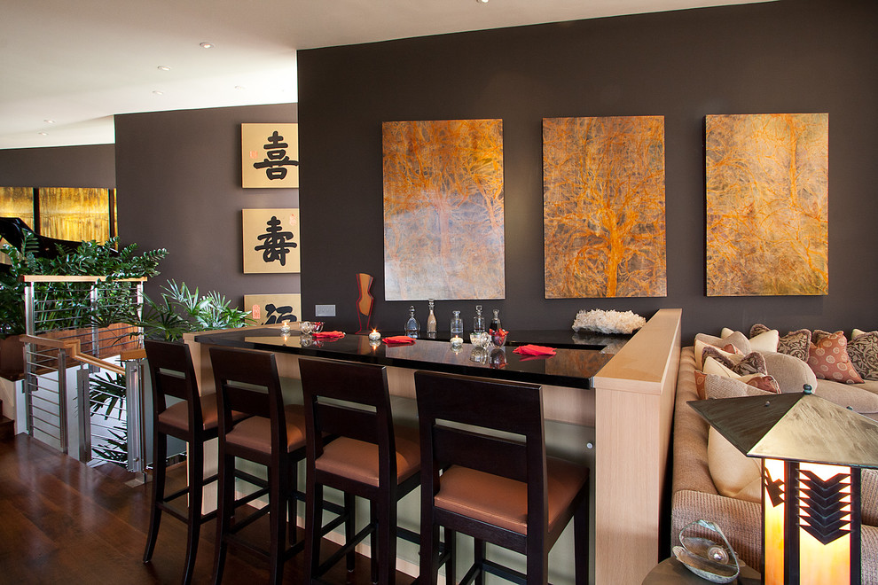 Cette image montre un bar de salon asiatique avec parquet foncé et un sol marron.