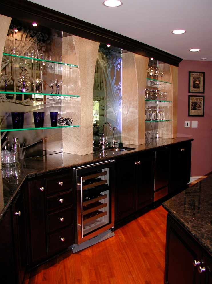 Example of a mid-sized trendy l-shaped medium tone wood floor seated home bar design in Chicago with an undermount sink, flat-panel cabinets, black cabinets, granite countertops and mirror backsplash