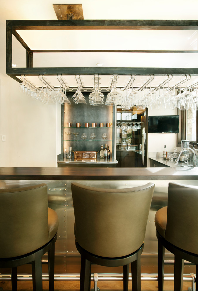 Photo of a small rustic u-shaped breakfast bar in Denver with grey splashback, stainless steel worktops and medium hardwood flooring.