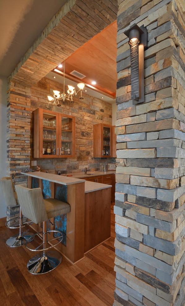 Example of a large transitional u-shaped medium tone wood floor seated home bar design in Austin with medium tone wood cabinets, multicolored backsplash and stone tile backsplash