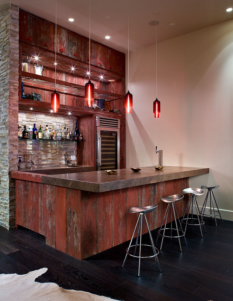 Example of a large urban galley dark wood floor and black floor seated home bar design in Las Vegas with distressed cabinets and multicolored backsplash