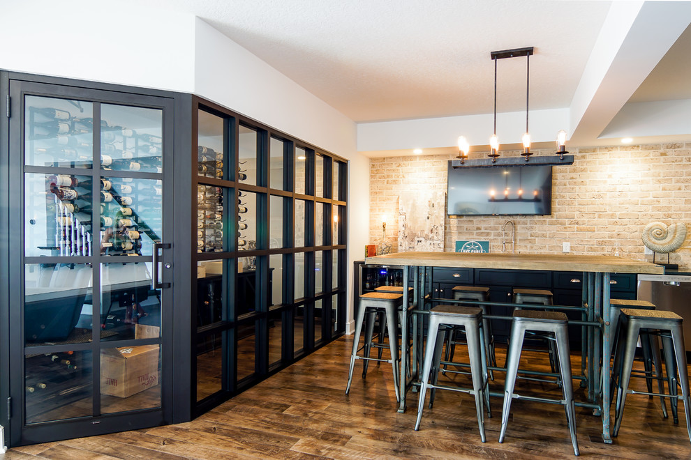 Example of a mid-sized farmhouse single-wall dark wood floor and brown floor seated home bar design in Cleveland with no sink and brick backsplash