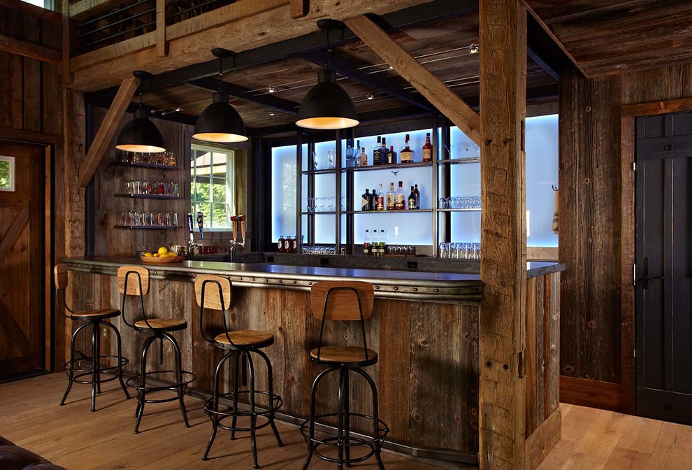 Example of a country u-shaped medium tone wood floor and beige floor home bar design in New York with dark wood cabinets