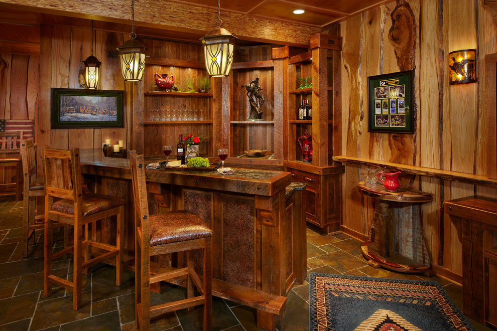 Idee per un grande bancone bar stile rurale con pavimento in ardesia, ante con riquadro incassato e ante in legno bruno