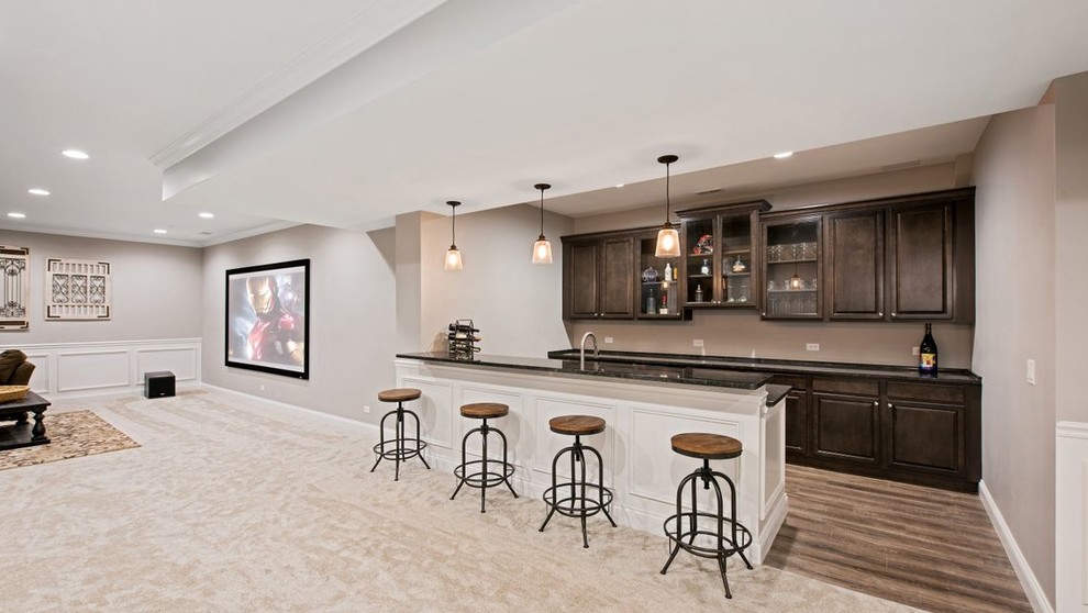 Immagine di un grande angolo bar con lavandino chic con ante con bugna sagomata, ante in legno bruno, pavimento in legno massello medio, pavimento marrone e top marrone