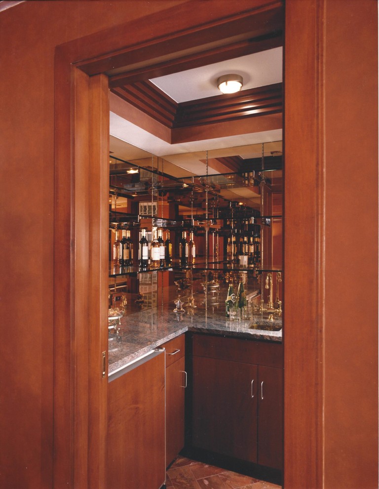 Immagine di un piccolo angolo bar con lavandino classico con lavello sottopiano, ante in legno scuro, top in marmo, paraspruzzi a specchio e pavimento in legno massello medio