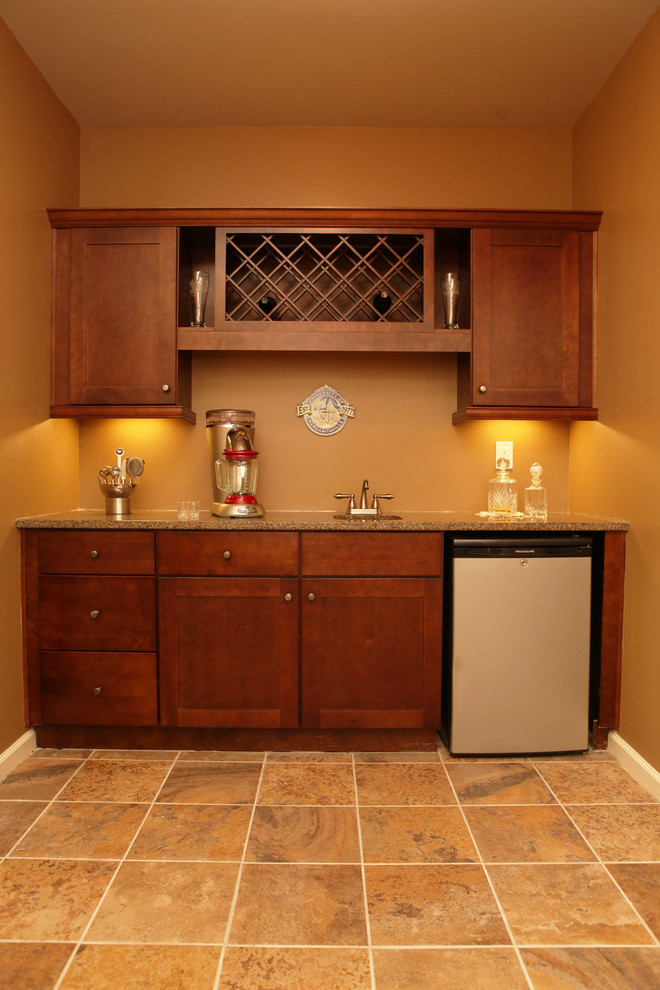 Photo of a medium sized classic galley wet bar in Atlanta with shaker cabinets, medium wood cabinets, granite worktops and ceramic flooring.